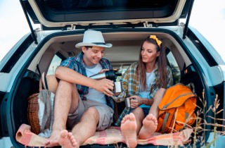 immagine di una coppia appassionata di viaggi on the road, che fanno un picnic in macchina