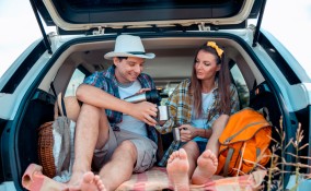immagine di una coppia appassionata di viaggi on the road, che fanno un picnic in macchina